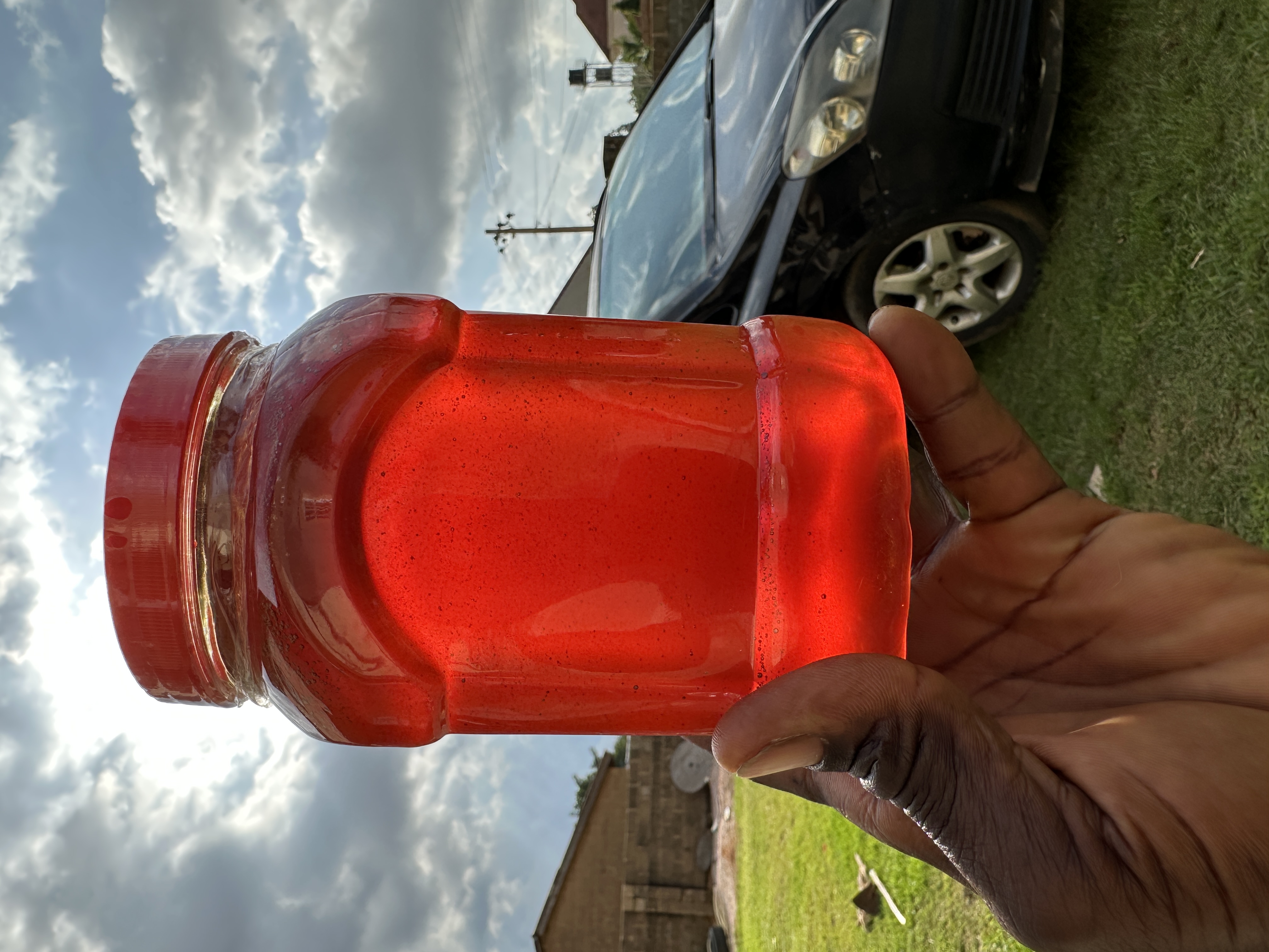 1 litre jar of glowing raw honey with a red lid